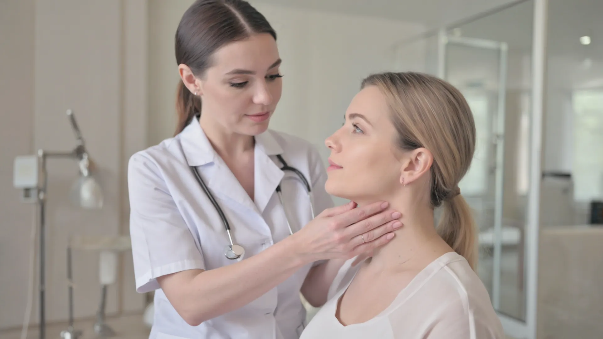 Doctor examining a patient's neck and jawline during an assessment consultation at Amara Clinic, Dublin